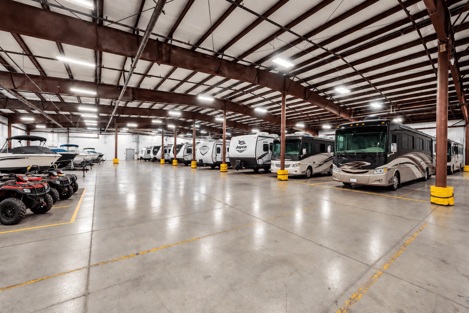 Rows of RVs, boats, and UTVs parked inside the heated Jenson Indoor Storage building in Logan, Utah